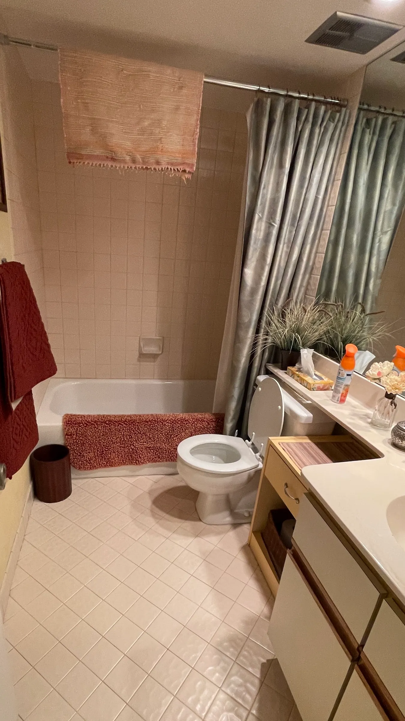 The bathroom before remodeling, with the original bathtub, wall tile, toilet and vanity.